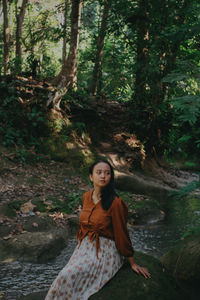 Portrait of young woman standing in forest
