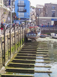 Boats moored in city against sky