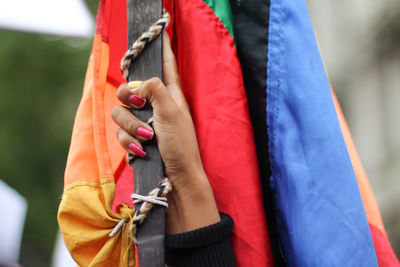 Cropped hand holding colorful flag
