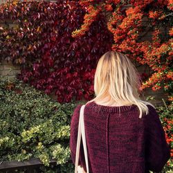 Rear view of woman standing by plants during autumn