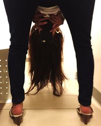 Low section of woman standing on tiled floor