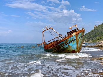 Fishing boat on sea against sky