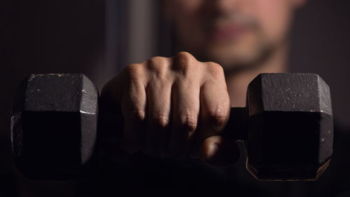 Close-up of man lifting dumbbell