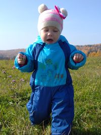 Full length of cute baby girl standing on field