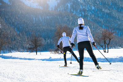 Rear view of people skiing on snow