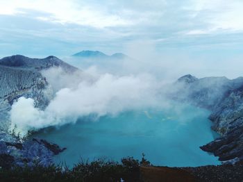 Smoke emitting from volcanic mountain against sky