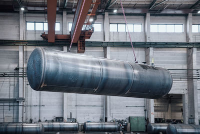 Large tank is lifted in an industry cunstruction hall by a heavy duty crane