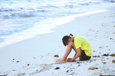 Sad teenage girl sitting on the beach