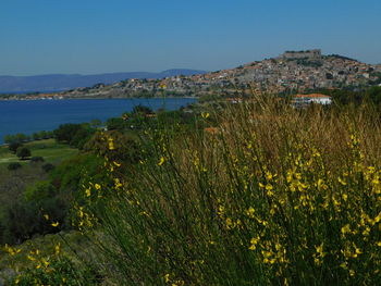 Scenic view of sea and mountains against clear blue sky