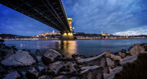 Bridge over river against cloudy sky