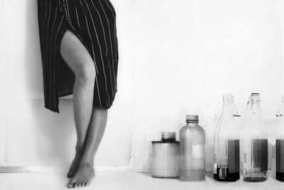 Low section of woman standing on wooden floor at home