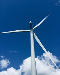 Low angle view of wind turbine against blue sky