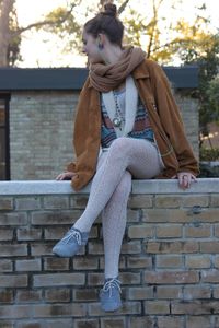 Full length of young man sitting on brick wall