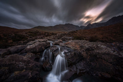 Scenic view of waterfall against sky