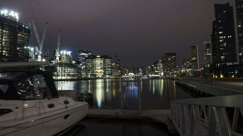 Boat moored at harbor in city at night