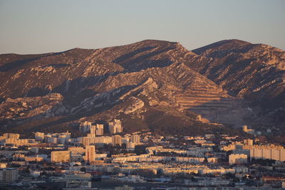 Aerial view of townscape by mountains against clear sky