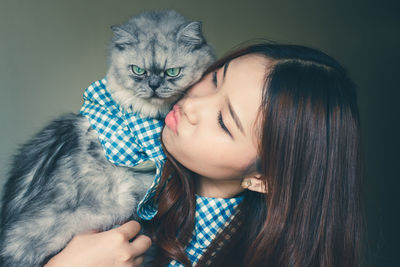 Close-up of young woman kissing cat