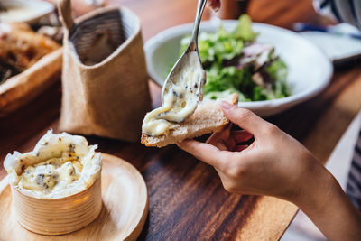 Cropped hand having food at table