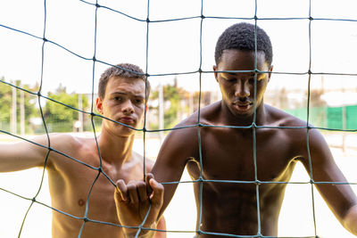 Portrait of two young multiethnic basketball players on the playing field on a sunny summer day
