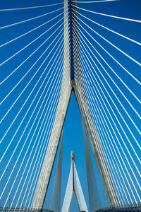 Low angle view of suspension bridge against blue sky