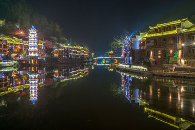 Reflection of illuminated houses on river at night