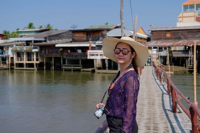 Young woman standing against wall in canal