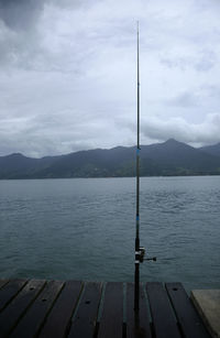 Scenic view with abandoned fishing rod of lake shore