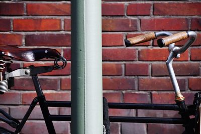 Close-up of bicycle against brick wall