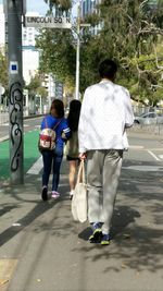 Rear view of woman walking on road