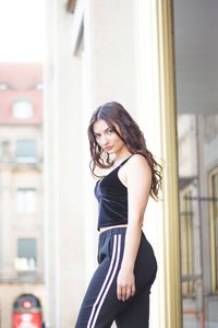 Portrait of beautiful woman standing against wall