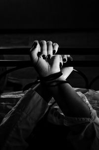 Cropped hands of woman tied on bed at home