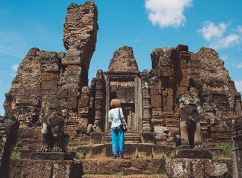 Rear view of woman standing at old ruined temple