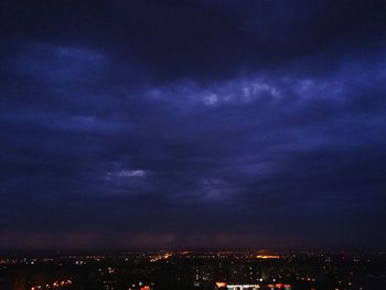 Illuminated cityscape against sky at night