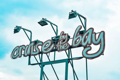 Low angle view of information sign against sky