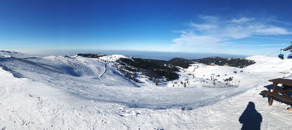 Scenic view of snowcapped mountains against blue sky