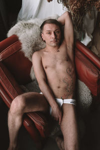Portrait of young man sitting on sofa