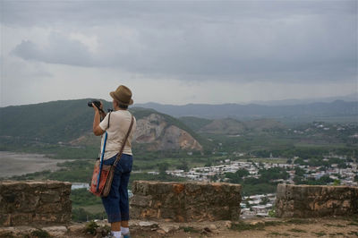 Rear view of man photographing from observation point