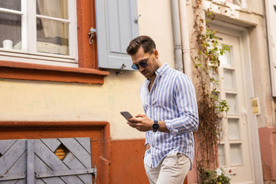 Full length of young man using mobile phone
