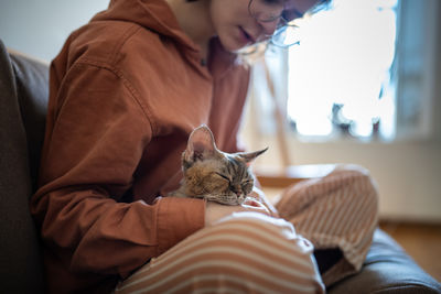 Midsection of woman holding cat