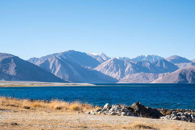 Scenic view of snowcapped mountains against clear blue sky