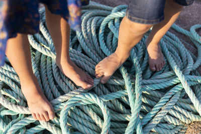 Low section of man wearing rope tied up outdoors