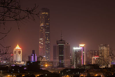 Illuminated buildings in city against sky at night