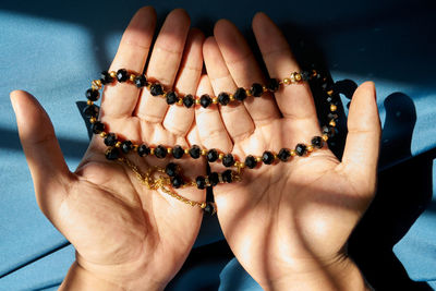 Midsection of muslim man holding rosary