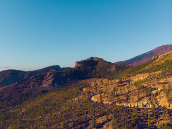 Scenic view of mountains against clear blue sky