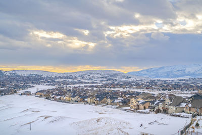 Aerial view of snow covered townscape against sky