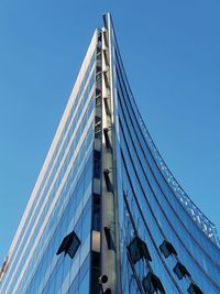 Low angle view of skyscraper against clear blue sky