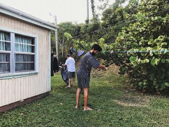 Side view of man drying clothes in yard