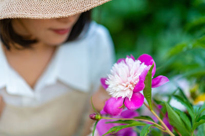 Close-up of woman holding pink flower