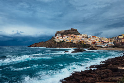 Scenic view of sea by buildings against sky