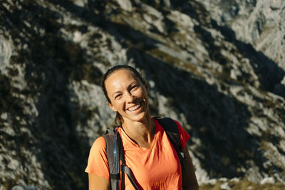 Portrait of a smiling young woman standing on rock